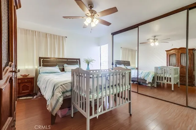 a bedroom with a bed a chandelier and dresser