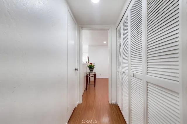 a view of a hallway with wooden floor and furniture