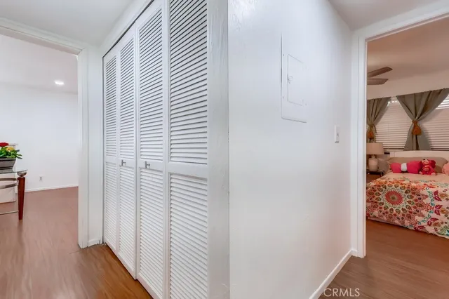 a view of a hallway with bed and wooden floor