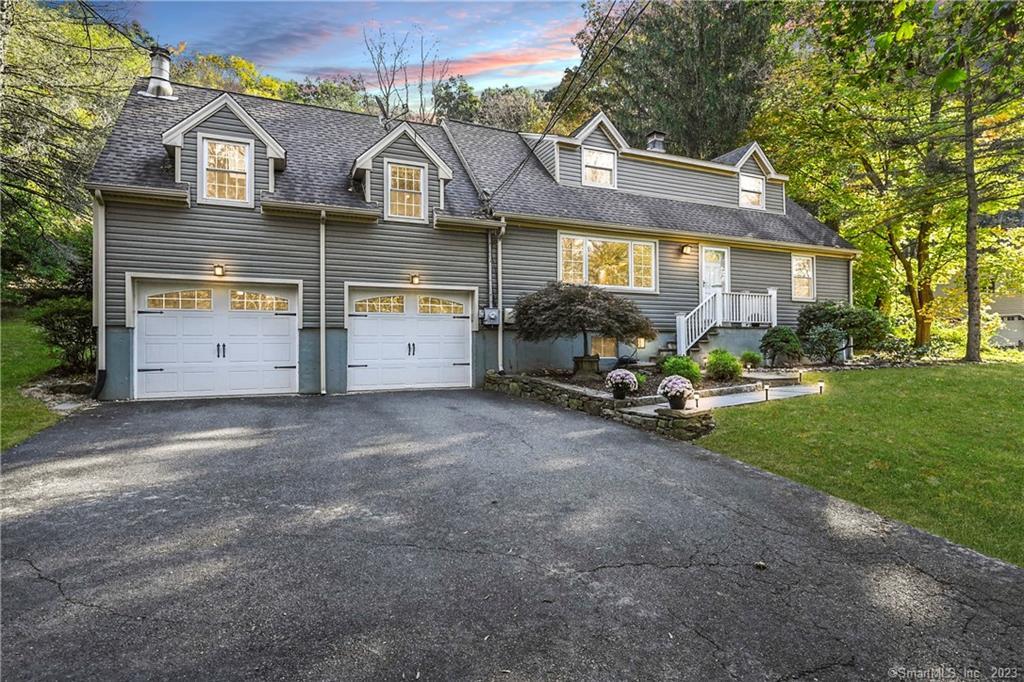 a view of a house with a yard and lawn chairs