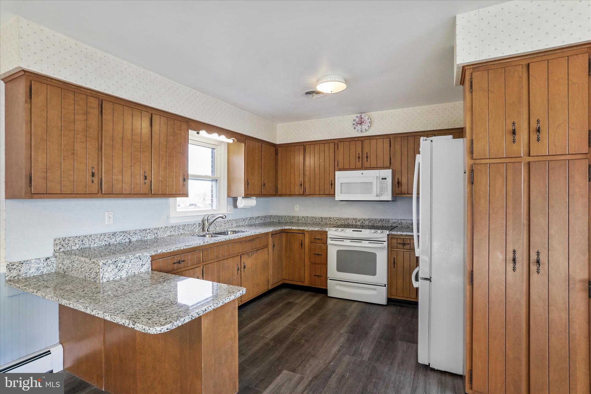 13728 Broadfording Church Road Hagerstown, MD 21740 - Photo 9 of 44 a kitchen with granite countertop wooden cabinets and white appliances