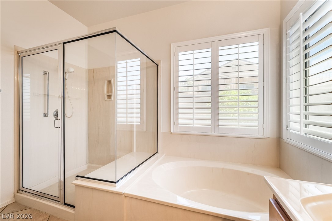 3033 Hartsville Road Henderson, NV 89052 - Photo 28 of 41 Relax in the deep soaking tub or the convenient walk-in shower of this private primary bath retreat.