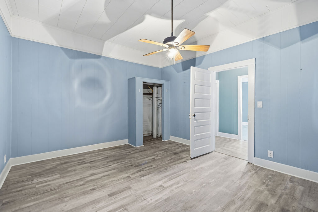 215 Louisiana Street Honea Path, SC 29654 - Photo 22 of 26 This airy bedroom features modern flooring and a classic ceiling fan, offering a comfortable retreat.