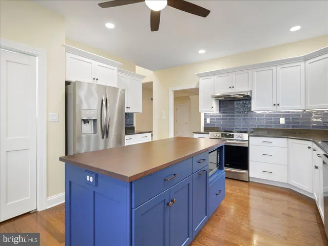 a kitchen with stainless steel appliances granite countertop a refrigerator a sink dishwasher a stove and a refrigerator