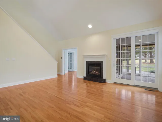 a view of empty room with wooden floor and fireplace
