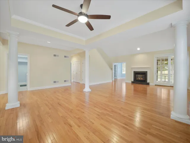 a view of a livingroom with wooden floor and a ceiling fan