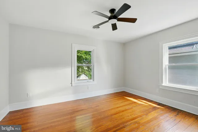 an empty room with a window and a fan