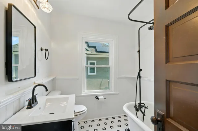 a bathroom with a sink a toilet and a mirror