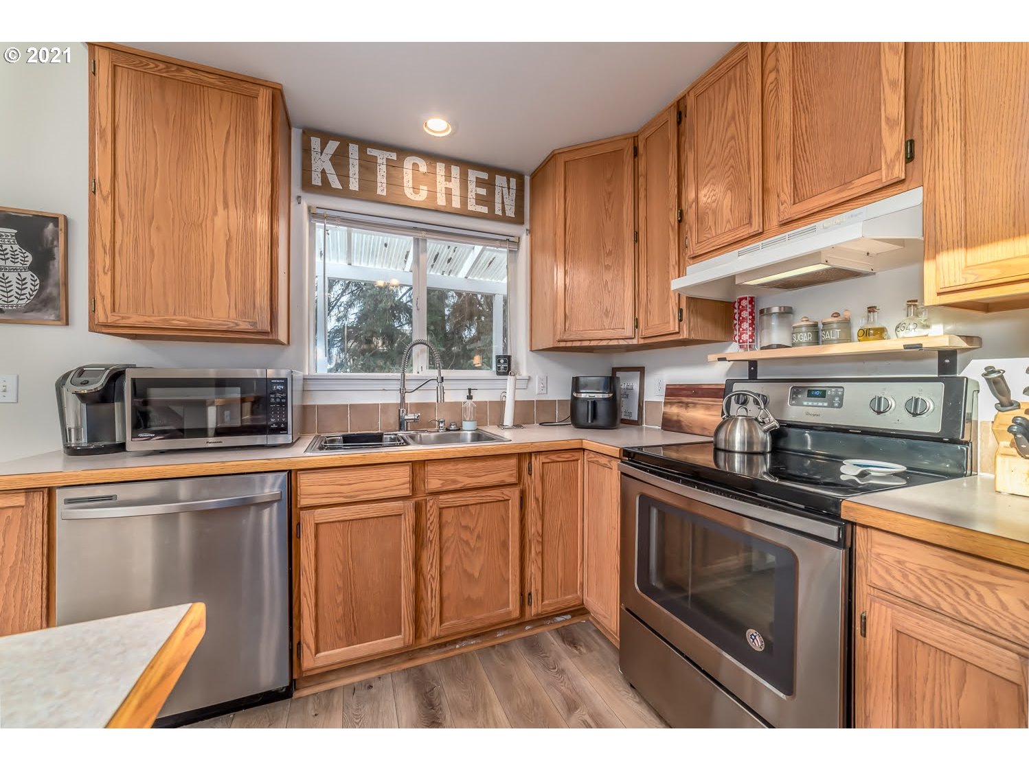 238 South 68th Court Springfield, OR 97478 - Photo 11 of 31 a kitchen with stainless steel appliances granite countertop a stove a sink dishwasher and cabinets with wooden floor