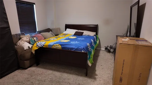 a bedroom with a bed window and dresser