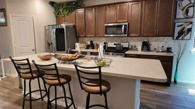 a kitchen with stainless steel appliances and refrigerator