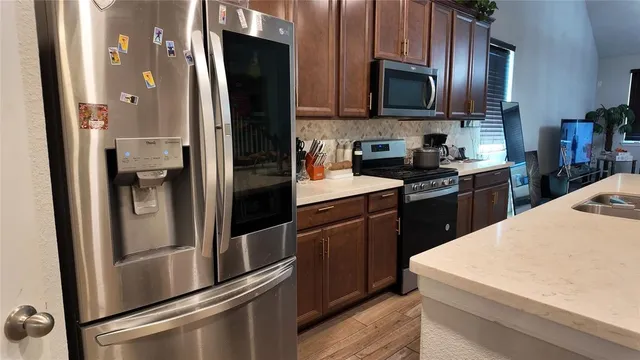 a kitchen with kitchen island granite countertop wooden floors and stainless steel appliances