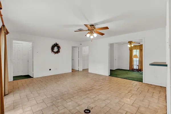 a view of empty room with window and ceiling fan