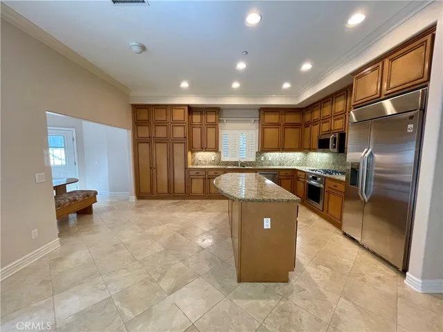 a kitchen with stainless steel appliances granite countertop a refrigerator and a sink