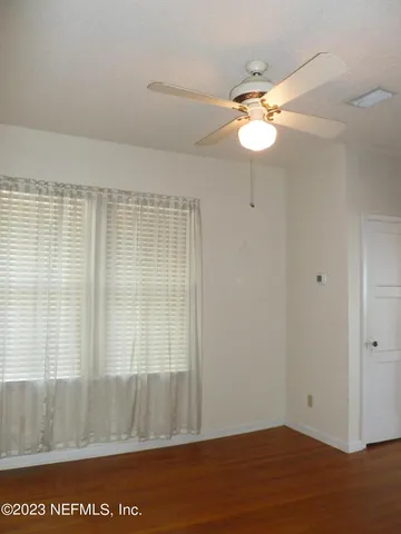 a view of a room with wooden floor and fan