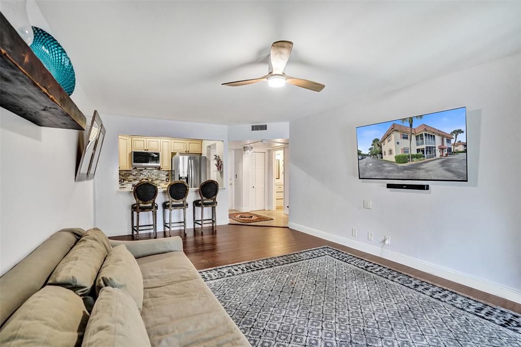 101 East McNab Road, Unit 407 Pompano Beach, FL 33060 - Photo 13 of 29 a living room with furniture and wooden floor