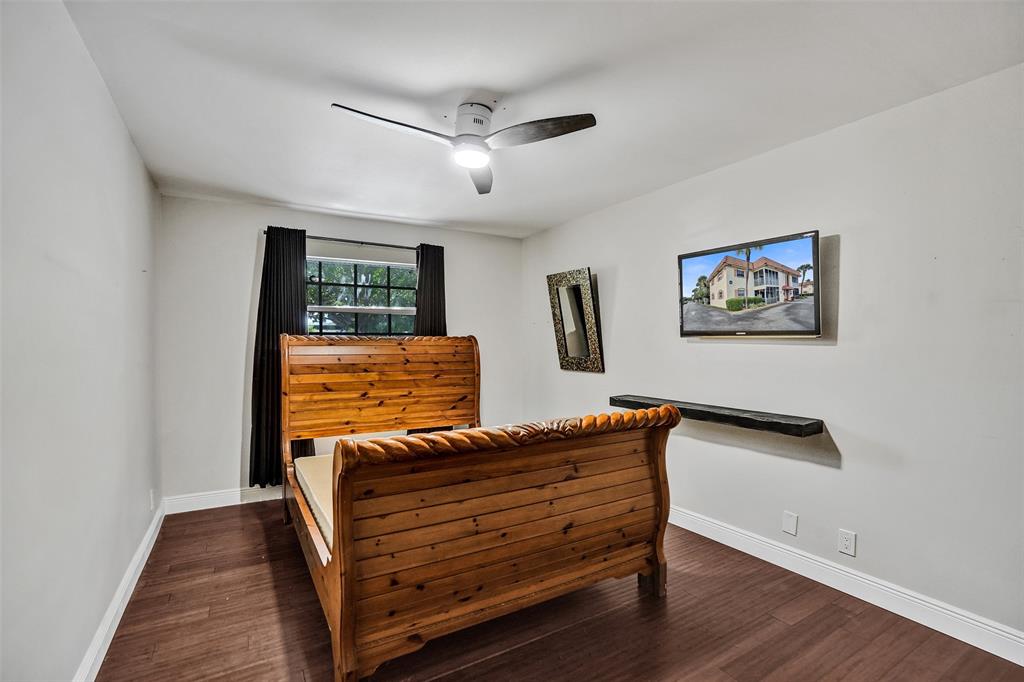 101 East McNab Road, Unit 407 Pompano Beach, FL 33060 - Photo 18 of 29 a bedroom with furniture and wooden floor