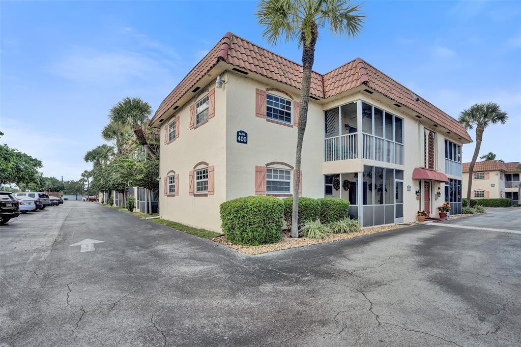 101 East McNab Road, Unit 407 Pompano Beach, FL 33060 - Photo 21 of 29 a front view of a house with a garden