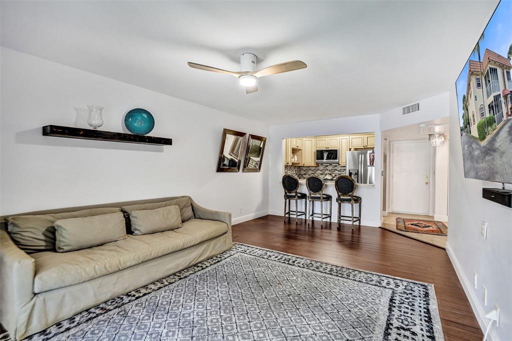 101 East McNab Road, Unit 407 Pompano Beach, FL 33060 - Photo 4 of 29 a living room with furniture a rug and a chandelier