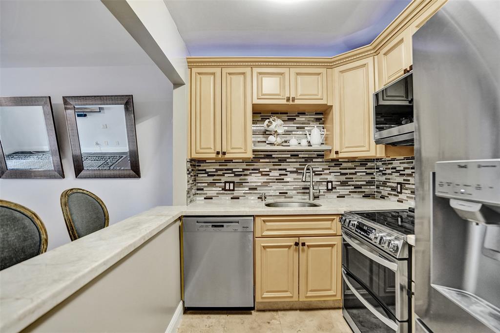 101 East McNab Road, Unit 407 Pompano Beach, FL 33060 - Photo 5 of 29 a kitchen with stainless steel appliances granite countertop a stove a sink and a microwave