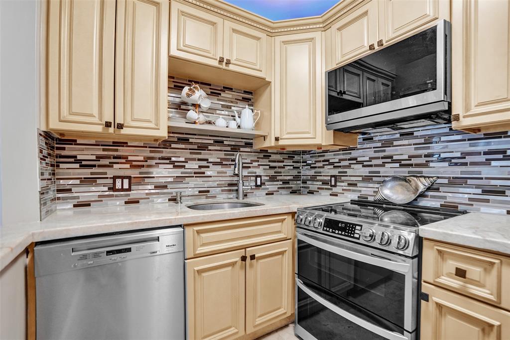 101 East McNab Road, Unit 407 Pompano Beach, FL 33060 - Photo 6 of 29 a kitchen with granite countertop white cabinets appliances and a sink