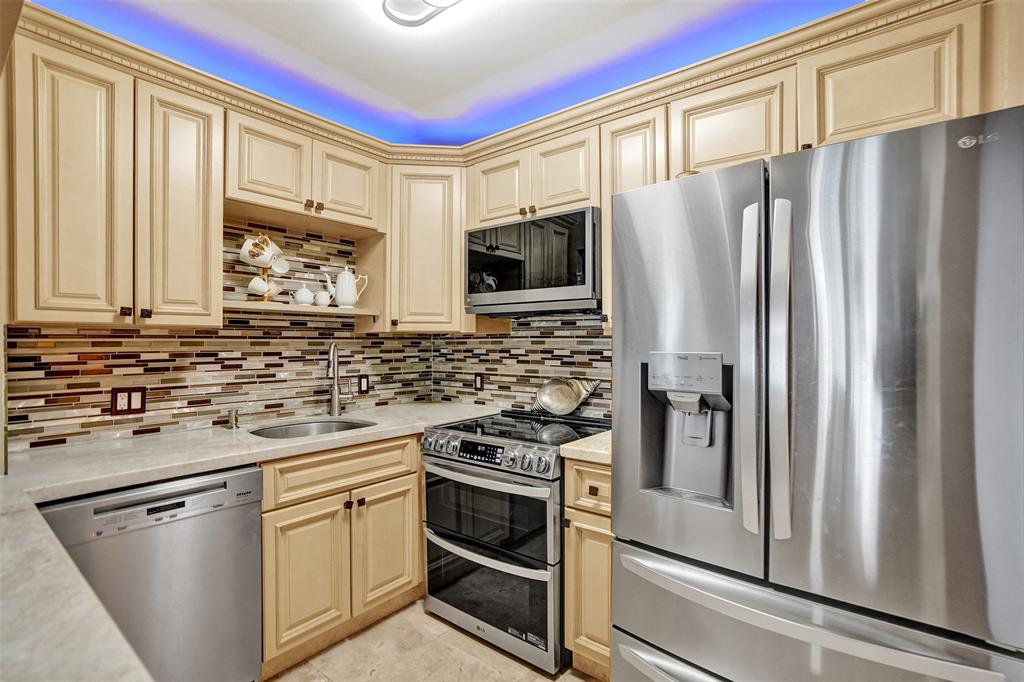 101 East McNab Road, Unit 407 Pompano Beach, FL 33060 - Photo 9 of 29 a kitchen with stainless steel appliances a refrigerator stove and microwave