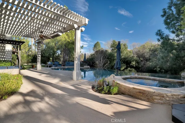 an aerial view of a house with swimming pool and outdoor seating