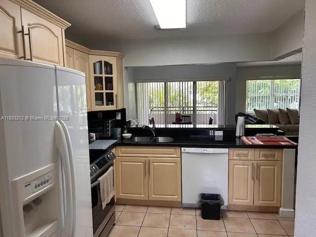 a kitchen with stainless steel appliances granite countertop a sink and a refrigerator