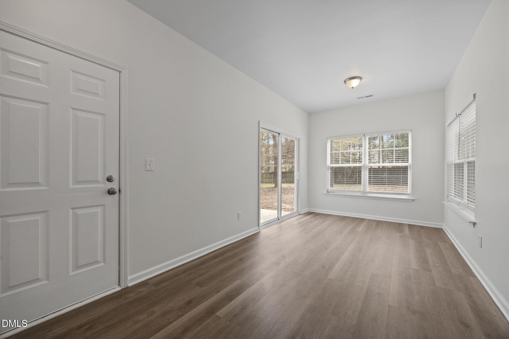 1071 Heritage Manor Drive Raleigh, NC 27610 - Photo 13 of 42 a view of an empty room with wooden floor and a window