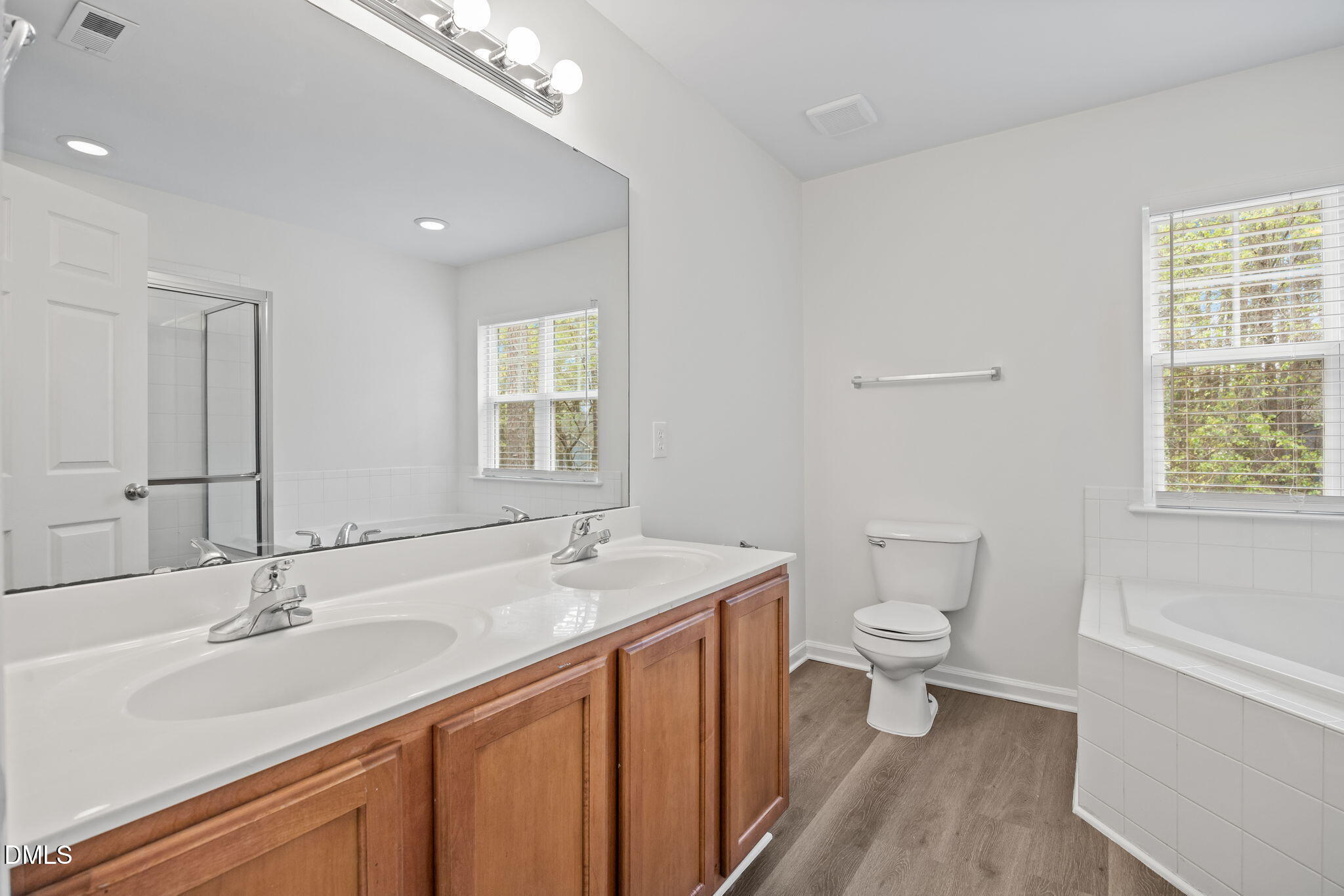 1071 Heritage Manor Drive Raleigh, NC 27610 - Photo 20 of 42 a bathroom with a sink a toilet a large mirror and shower