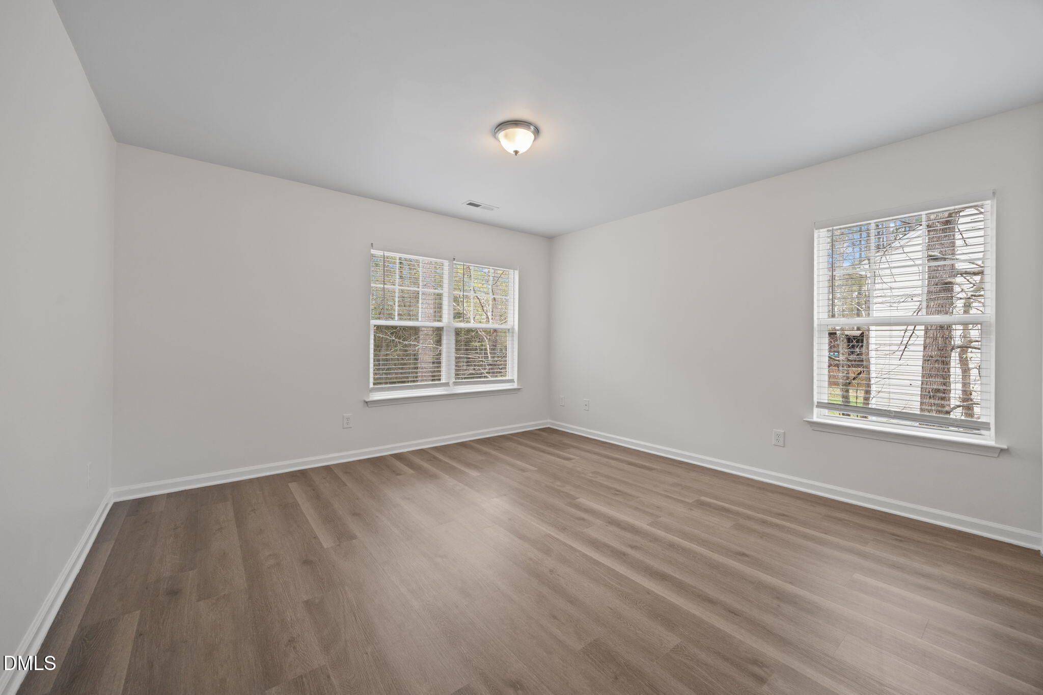 1071 Heritage Manor Drive Raleigh, NC 27610 - Photo 22 of 42 an empty room with wooden floor and windows