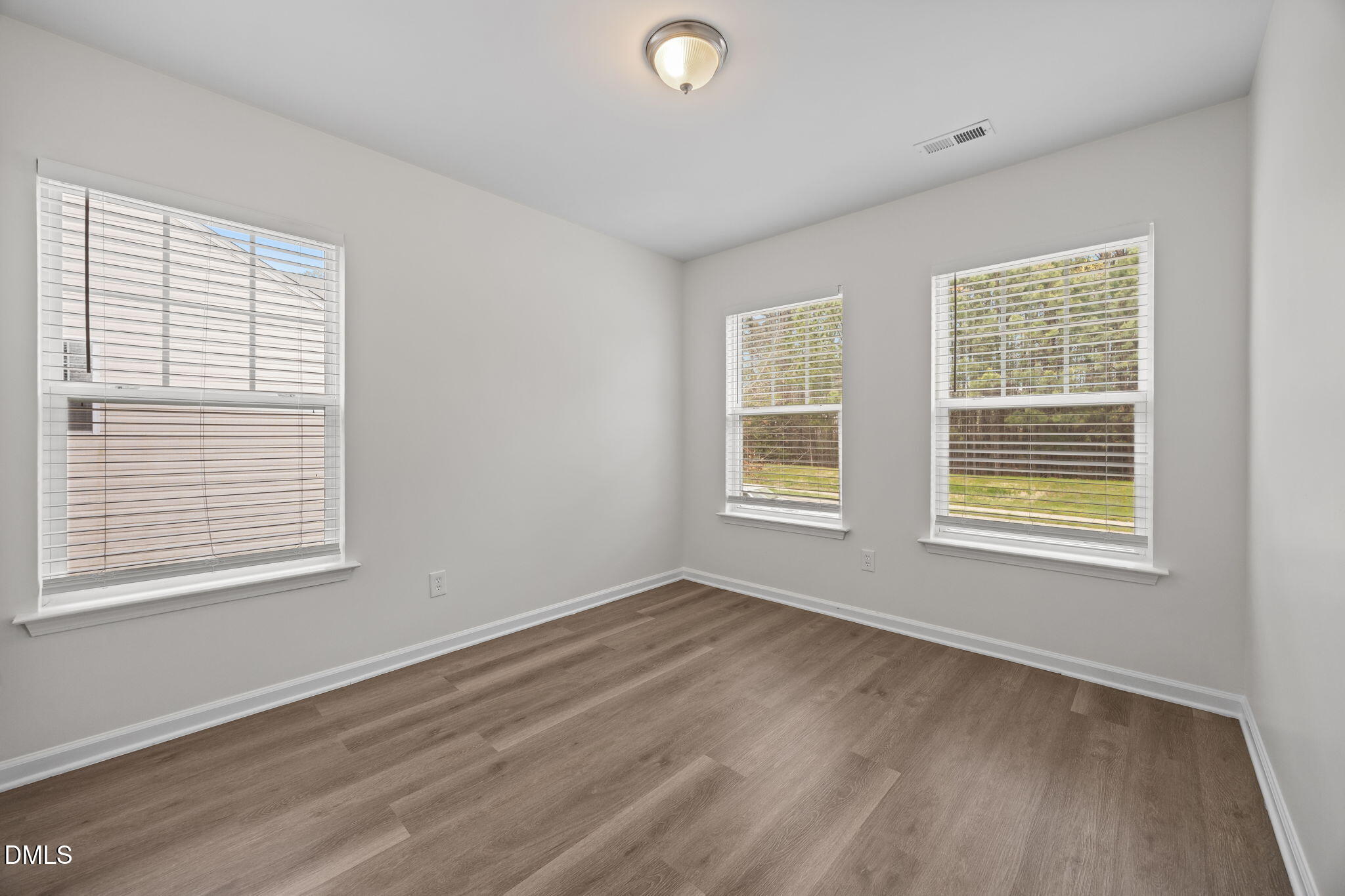 1071 Heritage Manor Drive Raleigh, NC 27610 - Photo 28 of 42 a view of an empty room with wooden floor and a window