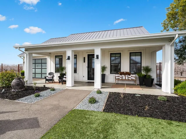 a kitchen with white cabinets stainless steel appliances and wooden floor