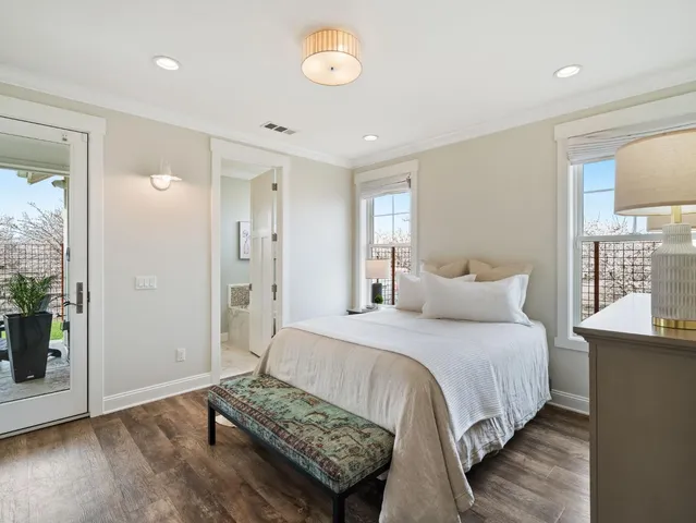 a bedroom with a bed and a flat tv screen on the dresser