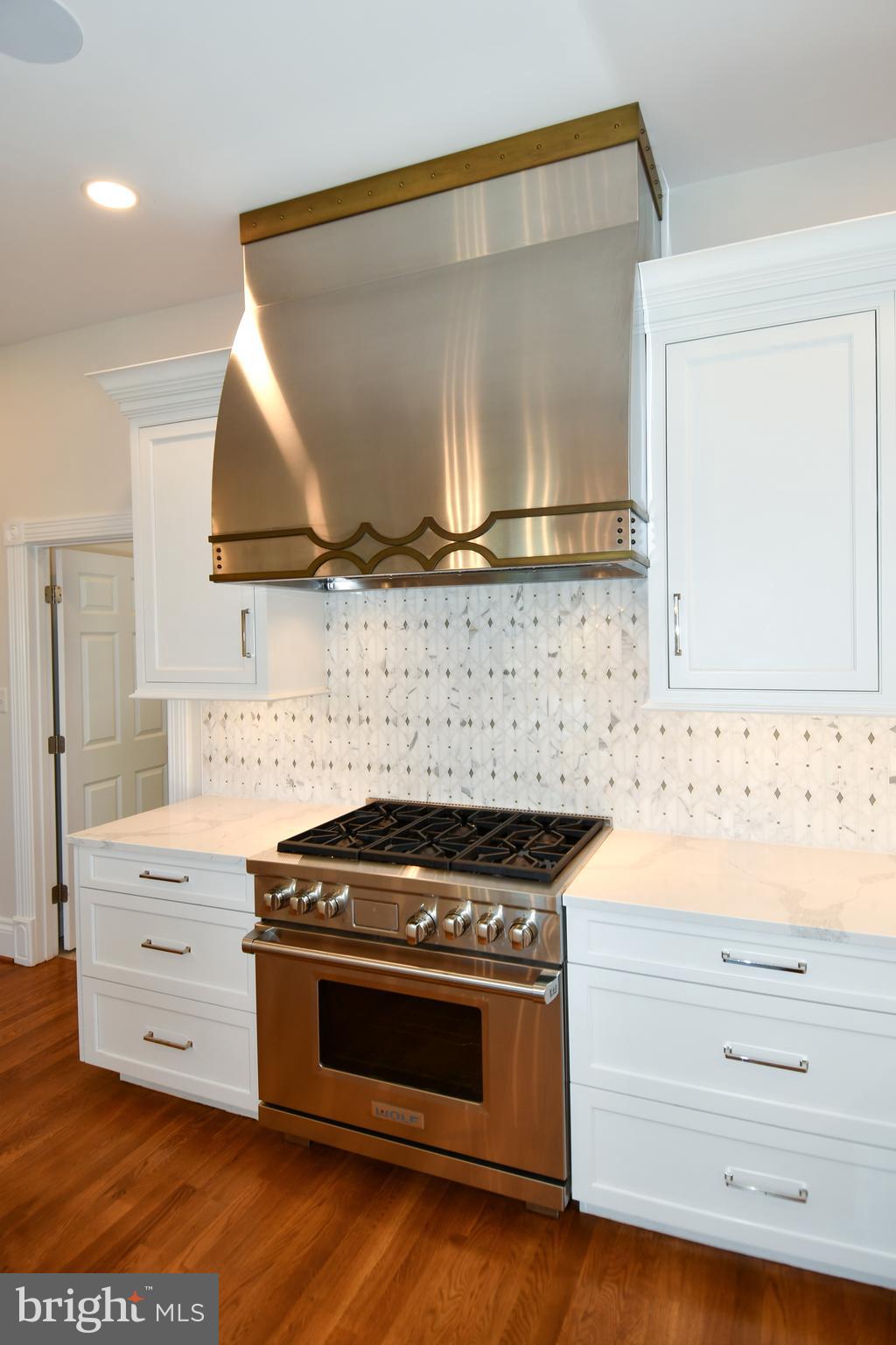 7808 Southdown Road Alexandria, VA 22308 - Photo 43 of 99 a kitchen with granite countertop a stove and a wooden floor