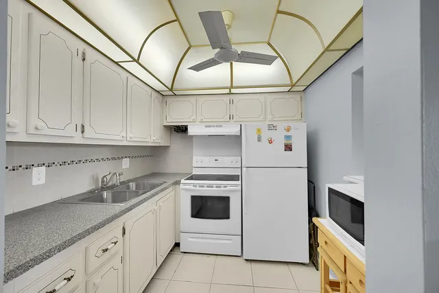 a kitchen with stainless steel appliances white cabinets and white appliances
