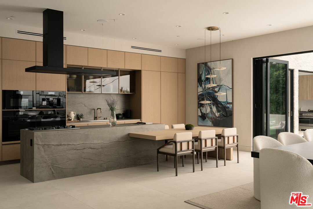 9919 Girla Way Los Angeles, CA 90064 - Photo 5 of 31 a kitchen with stainless steel appliances kitchen island granite countertop a table and chairs in it