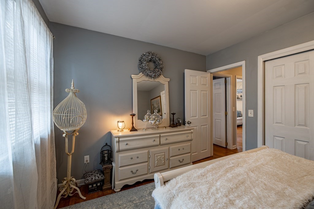 74 Walker Pond Road Sturbridge, MA 01566 - Photo 17 of 42 a bedroom with a bed and a chandelier