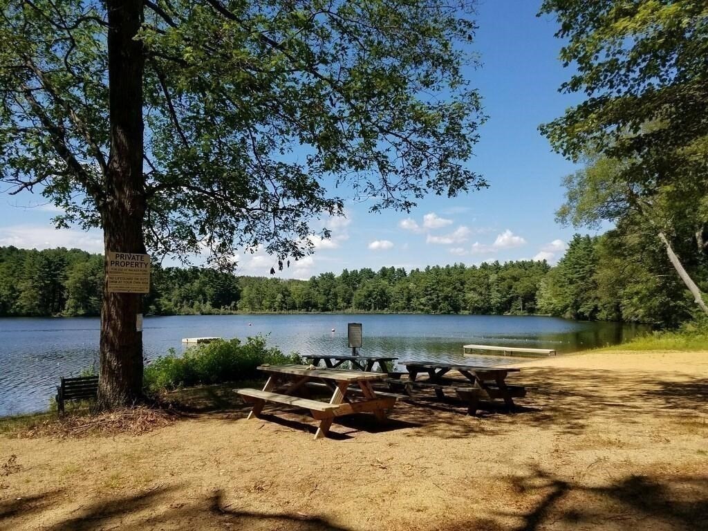 74 Walker Pond Road Sturbridge, MA 01566 - Photo 36 of 42 a wooden bench sitting next to a lake