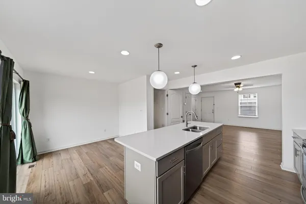 a kitchen with a sink and wooden floor