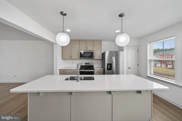 a kitchen with a center island a counter space and wooden floor
