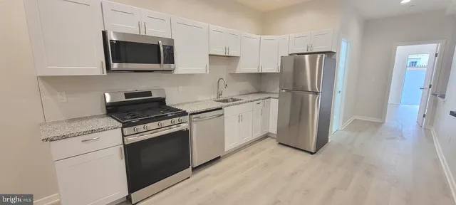 a kitchen with stainless steel appliances a stove microwave and refrigerator