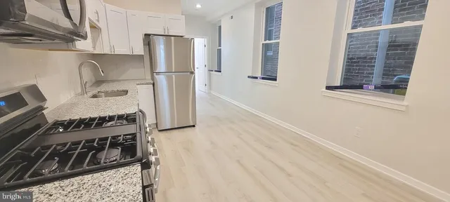 a kitchen with a refrigerator stove and sink