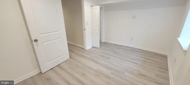 an empty room with wooden floor and entrance