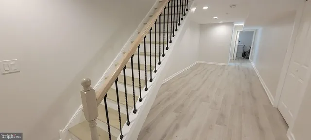 a view of a hallway with wooden floor and staircase