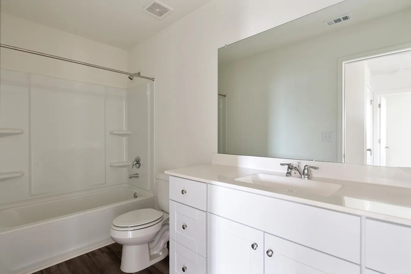 101 Aoudad Road Hutto, TX 78634 - Photo 4 of 39 Bright, refreshed bathroom featuring a clean vanity, large mirror, and practical shower-tub combination.