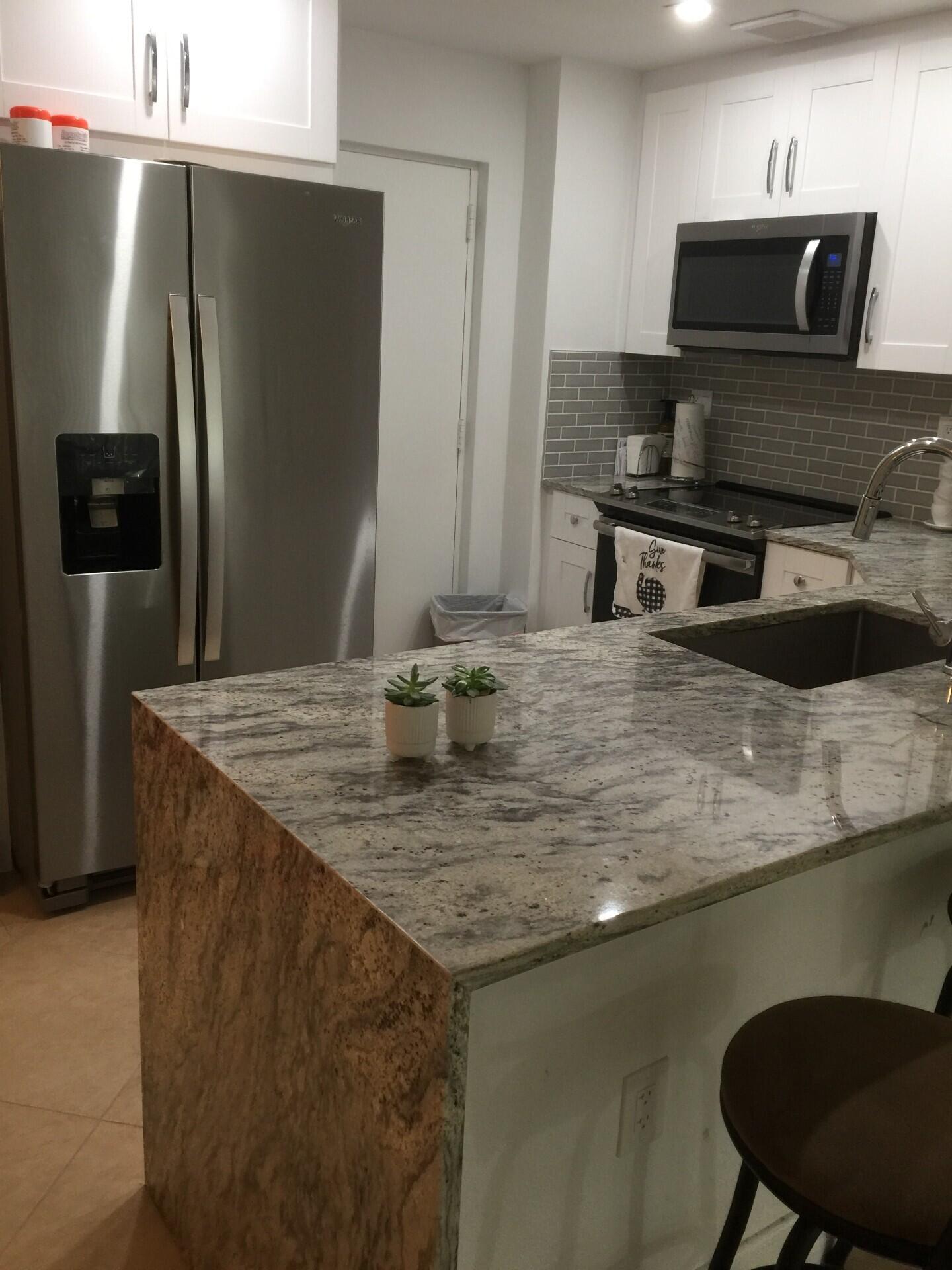 55 Southwest 2nd Avenue, Unit 2030 Boca Raton, FL 33432 - Photo 5 of 14 a kitchen with stainless steel appliances granite countertop a sink a refrigerator and a stove