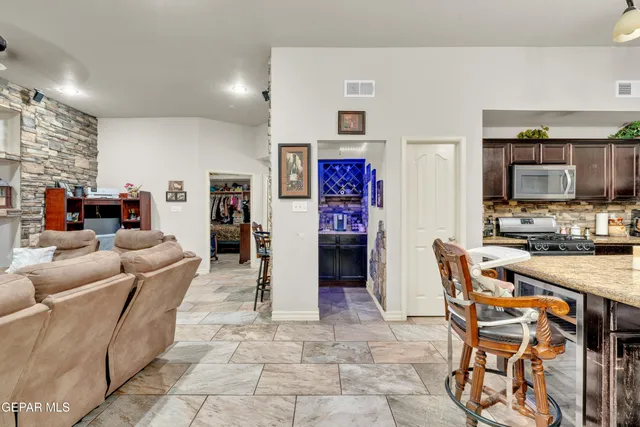 a living room with stainless steel appliances kitchen island granite countertop furniture and a kitchen view