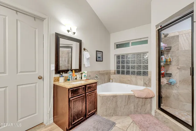 a bathroom with a tub sink and mirror