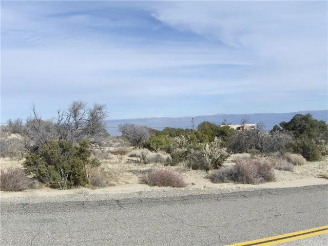 a view of a dry yard with mountains in the background